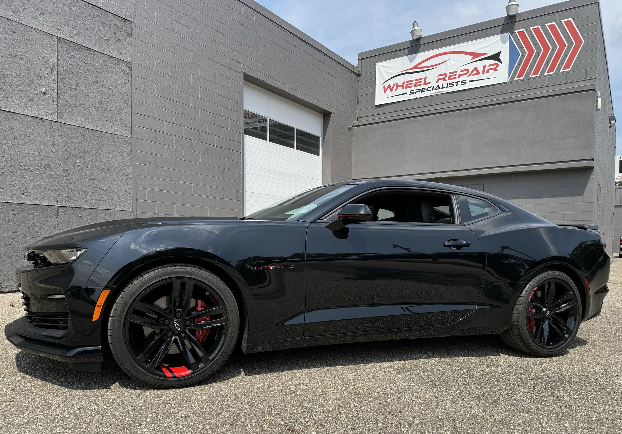 Black Chevrolet Camaro with black wheels and red accents