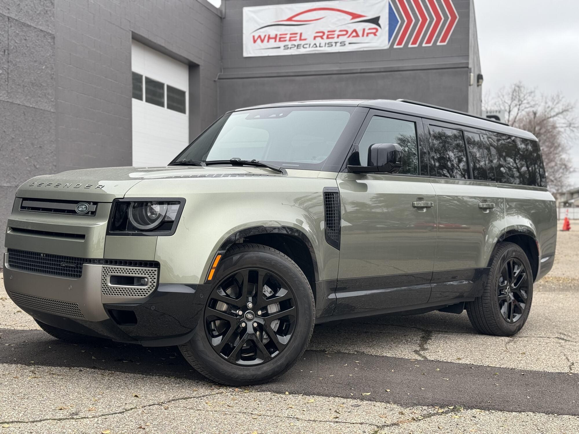 Green Land Rover Defender with gloss black wheels