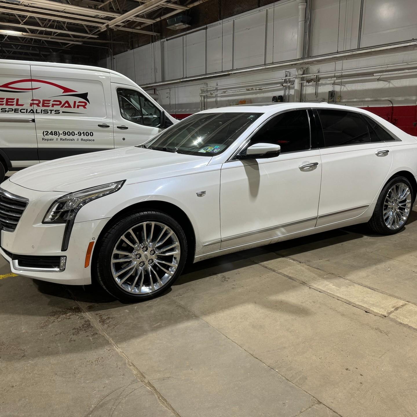 Cadillac CT6 in the shop bay beside the service van