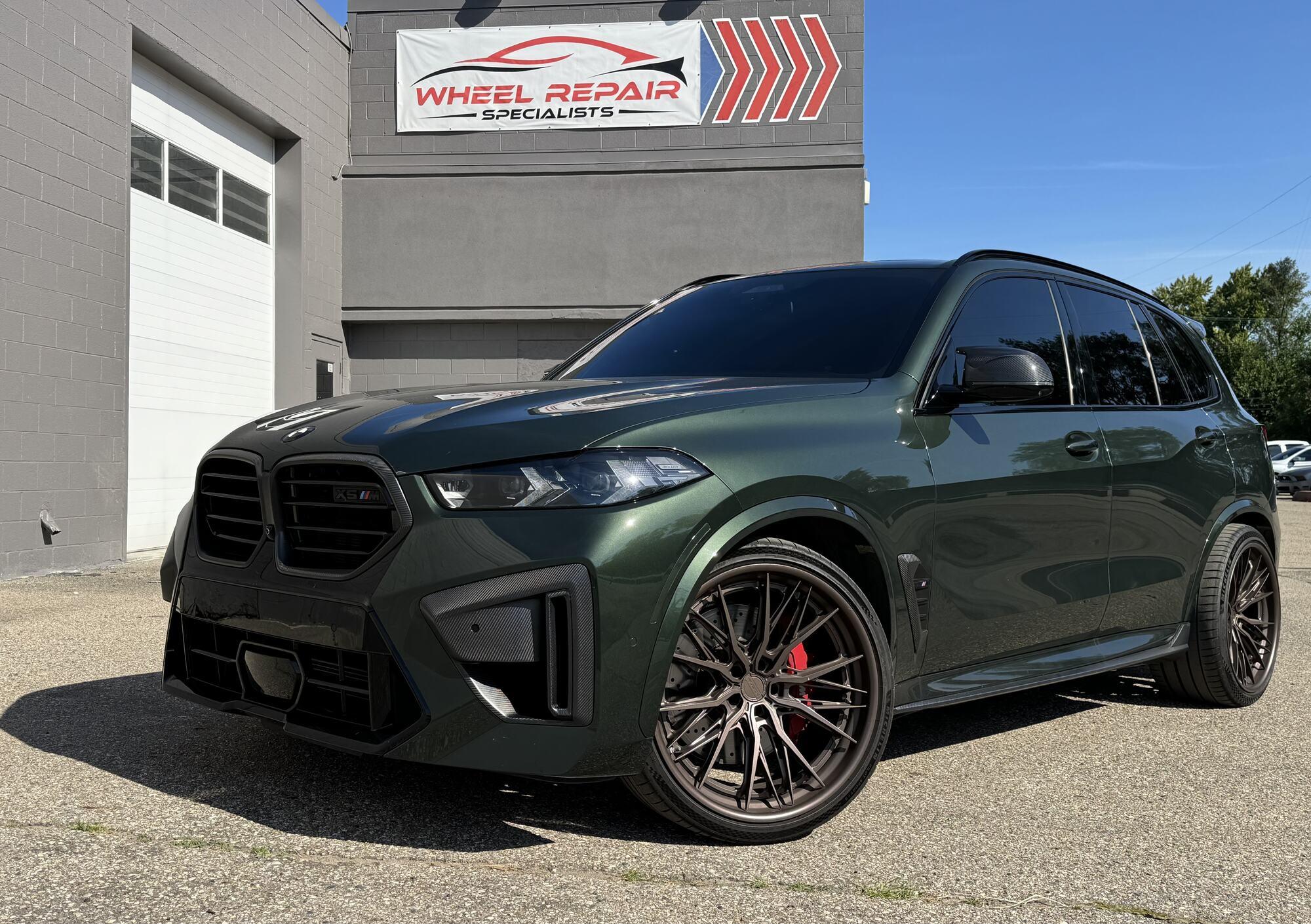 Green BMW X5 M with bronze wheels outside Wheel Repair Specialists